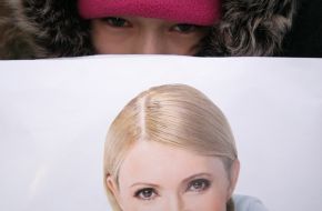 A girl holds a placard with portrait of Yuliya Timoshenko