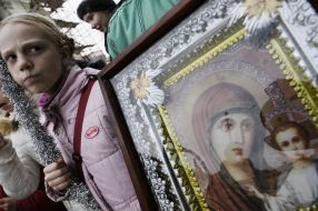 A girl stands near an icon