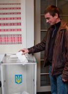 An elector gives up a bulletin in an box for voting