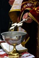 Священнослужитель держит крест