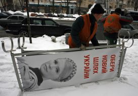 Worker dismantle propaganda billboard