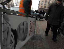 Worker dismantle propaganda billboard
