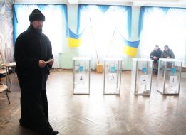 A priest holds a ballot paper