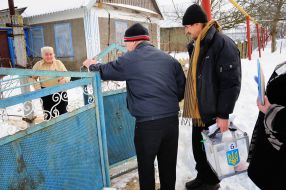 Election committee’s members carry a portable ballot-box