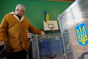 A man gives up a bulletin in an ballot box