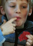 A boy eats fruit jellies