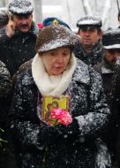 A woman holds the picture of the lost soldier