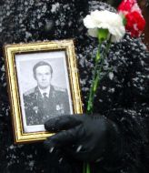 A woman holds the picture of the lost serviceman