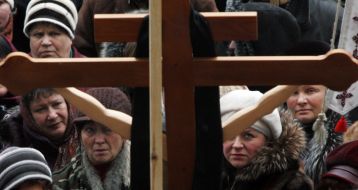 Participants of picket near a cross