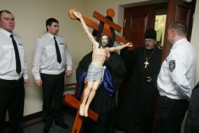 A priest carries a cross with the crucifix