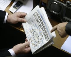 A people’s deputy reads the article in a newspaper