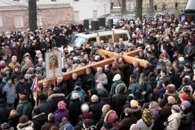 People are carrying a wooden cross