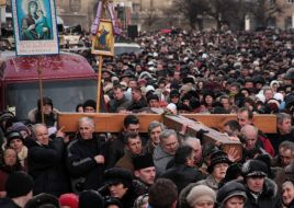 People are carrying a wooden cross