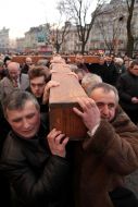 People are carrying a wooden cross