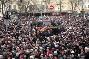 People are carrying a wooden cross