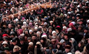 People are carrying a wooden cross