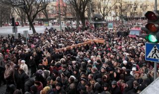 People are carrying a wooden cross