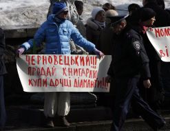 Участник митинга держит плакат