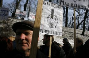 Участник митинга держит плакат