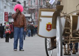 Чоловік в парику палить сигарету