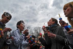 Young people inflate soap-bubbles
