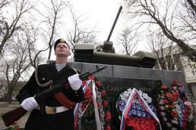 The soldier honor guard stands near the memorial ”Tank T-34”