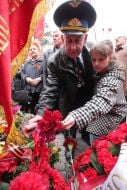 Veteran with his granddaughter, laying flowers