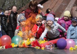 Children put flowers at the memorial flame