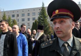 A priest blesses conscripts on military service