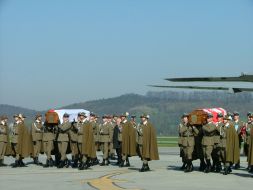 Soldiers of the Honor Guard carried out of the plane coffins