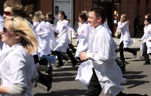 Young people in white dressing-gowns run