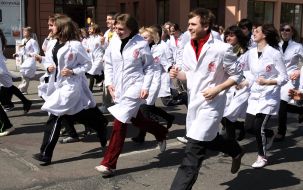 Young people in white dressing-gowns run