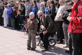 A man sits on child’s bicycle