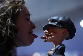 A visitor puts out tongue near the statuette of Lenin