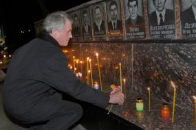 A man puts a candle near the Memorial to Heroes of Chernobyl