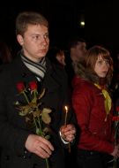 A fellow holds an alight candle