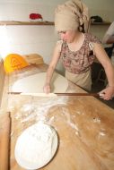 Женщина раскатывает тесто