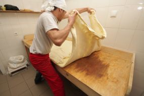 Мужчина раскатывает тесто