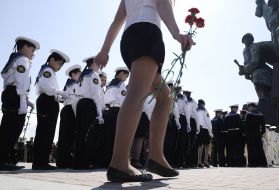 A schoolgirl carries flowers