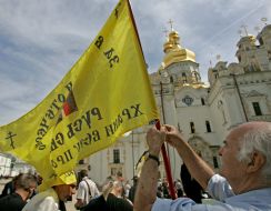 Участник шествия крепит флаг