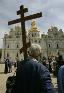 Участник шествия держит крест