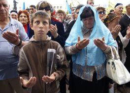 Участники траурного митинга совершают намаз
