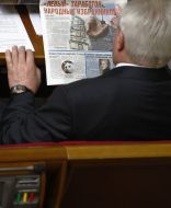 A people’s deputy reads the article in a newspaper