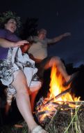 Participants of festival jump through a fire