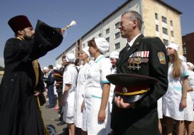 Священник освящает водой студентов-медиков и офицеров