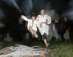 Boy and girl jumping over fire