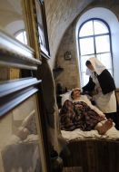 Муляж сестры милосердия возле койки больного