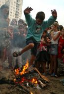 A boy jumps through a fire