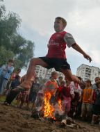 A boy jumps through a fire