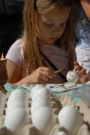 A girl covers with drawing pisanka